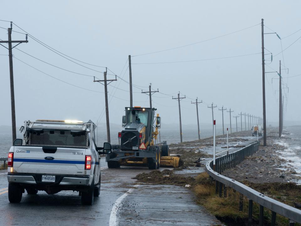 Highway crews clean debris caused by post-tropical storm Fiona on the Les Îles-de-la-Madeleine, Que., Saturday, Sept. 24, 2022.Strong rain and winds are lashing the Atlantic Canada region as Fiona hits as a powerful post-tropical cyclone. (Nigel Quinn /The Canadian Press via AP)