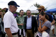 The Mayor of Surfside Charles Burkett, left, talks with Rachel Spiegel, right, who is looking for information on the Champlain Towers South Condo building, Saturday, June 26, 2021, in the Surfside area of Miami. The apartment building partially collapsed on Thursday. Spiegel's mother Judy lives in the building and is missing. Also shown are Spiegel's brothers Josh Spiegel, second from left, and Michael Spiegel, second from right, and her father Kevin Spiegel. (AP Photo/Lynne Sladky)