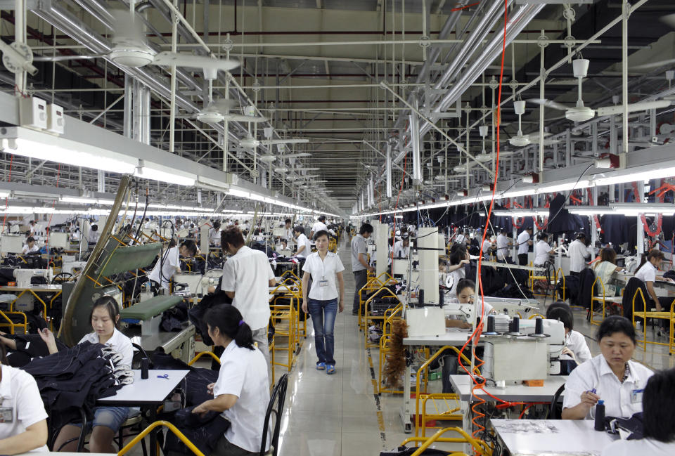 Workers make suits at a factory owned by the Baoxiniao Group on the outskirts of Shanghai. - Credit: Corbis via Getty Images