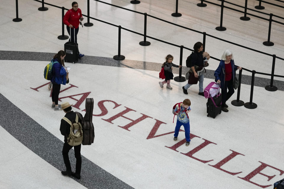 Travelers make their way through the Nashville International Airport, Tuesday, Nov. 21, 2023, in Nashville, Tenn. Despite inflation and memories of past holiday travel meltdowns, millions of people are expected to hit airports and highways in record numbers over the Thanksgiving Day break. (AP Photo/George Walker IV)