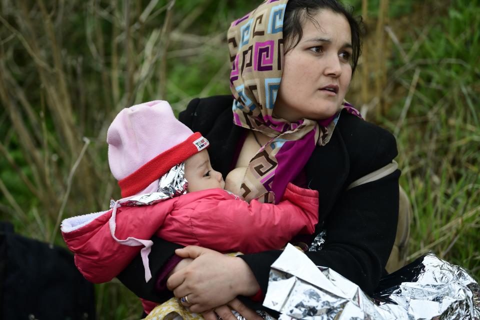 A woman breast feed her baby after the arrival of migrants at Eftalou beach, on the Greek island of Lesbos, after crossing on a dinghy the Aegean sea from Turkey, Sunday, March 1, 2020. Turkey's President Recep Tayyip Erdogan said his country's borders with Europe were open Saturday, making good on a longstanding threat to let refugees into the continent as thousands of migrants gathered at the frontier with Greece. (AP Photo/Michael Varaklas)
