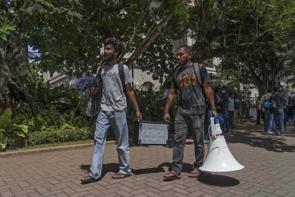 Protesters vacate the official residence of President Gotabaya Rajapaksa in Colombo, Sri Lanka, Thursday, July 14, 2022. Protest leader Devinda Kodagode told The Associated Press they were vacating official buildings after the Parliament speaker said he was seeking legal options to consider since Rajapaksa left without submitting his resignation letter as promised. (AP Photo/Rafiq Maqbool)