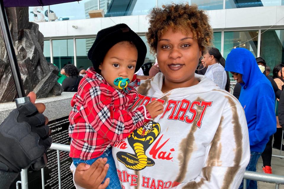 Jenifer Loving, 22, stands in line with her son, Mateo, for Takeoff's memorial in Atlanta.