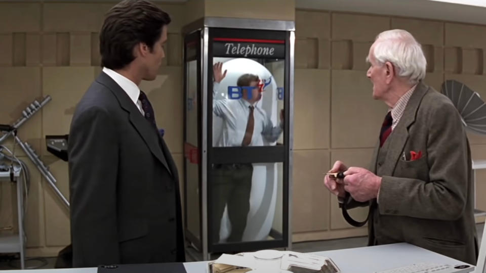 Pierce Brosnan and Desmond Llewelyn watch the smothering phone box go off in Goldeneye.