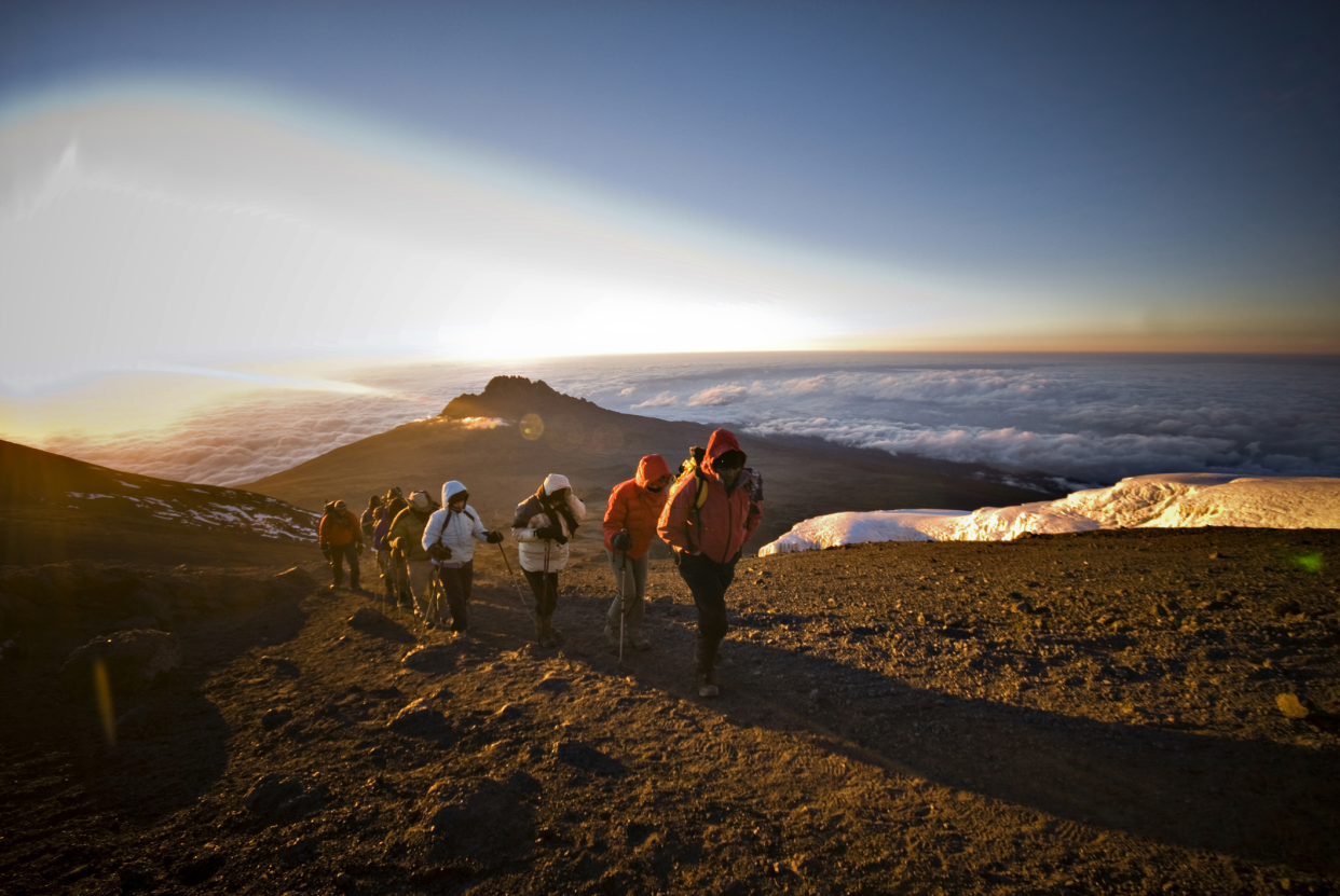 A Team of Hikers Approach the Summit of Mt. Kilimanjaro at Sunrise