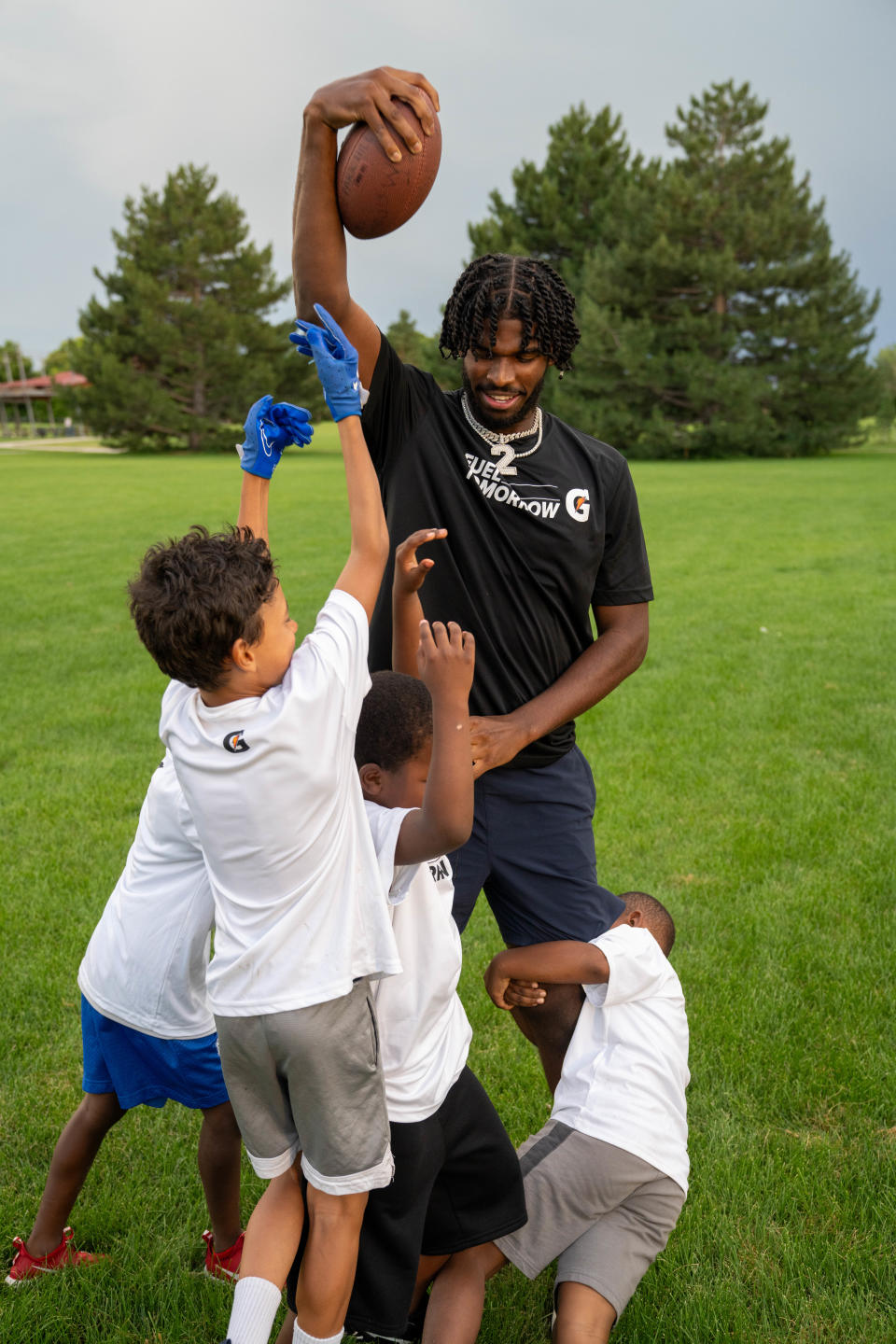 Colorado Buffaloes quarterback Shedeur Sanders plays football with kids at Fred Thomas Park in Denver as part of Gatorade’s Equity in Sports event, which gave equipment to the N.E.D Falcons football and cheerleading programs.