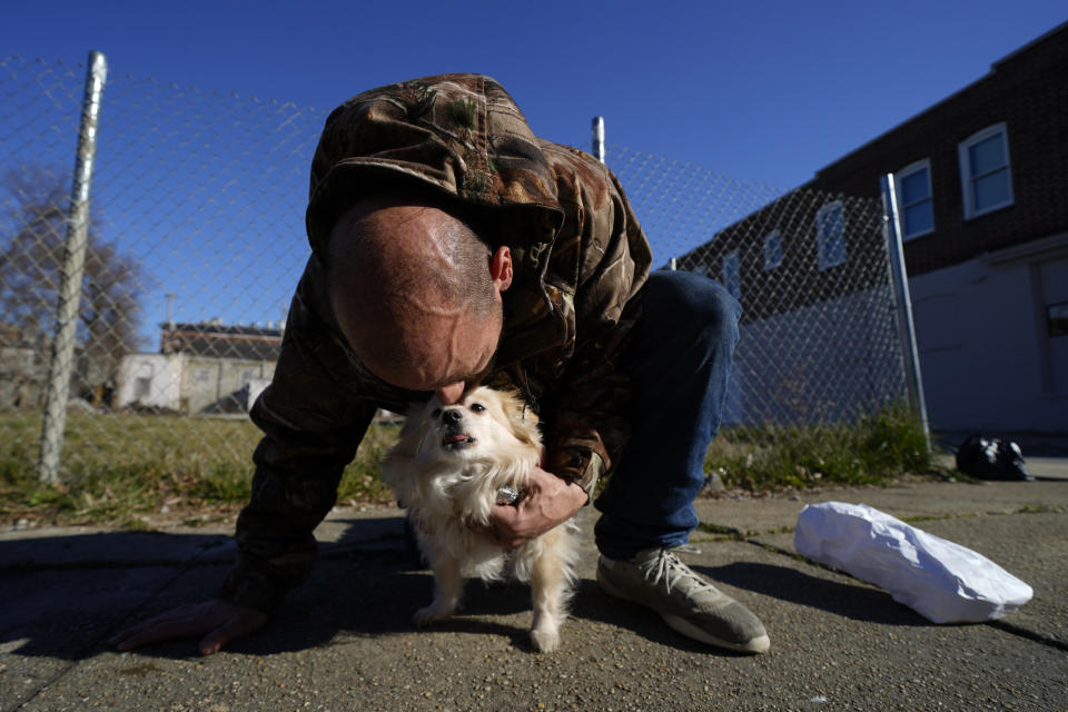 Anthony Kelly kisses his dog Annie Oakley after a health visit inside a Baltimore City Health Department RV, Tuesday, March 21, 2023, in Baltimore. The Baltimore City Health Department's harm reduction program uses the RV to address the opioid crisis, which includes expanding access to medication assisted treatment by deploying a team of medical staff to neighborhoods with high rates of substance abuse and offering buprenorphine prescriptions. (AP Photo/Julio Cortez)