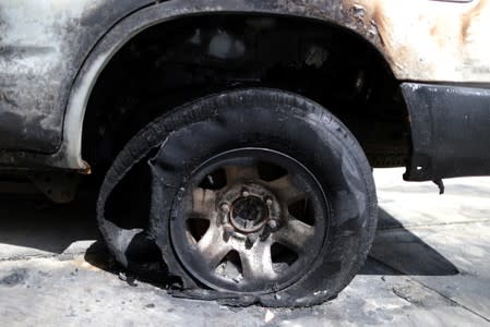 A burned car in the driveway of a suburban home that was the site of a hash oil extraction laboratory explosion is seen in the Mira Mesa area of San Diego