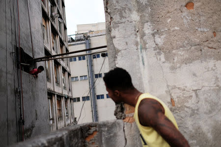 A resident of the abandoned Prestes Maia textile factory which is occupied by a homeless movement, jokes with a boy, in downtown Sao Paulo, Brazil, May 12, 2018. REUTERS/Nacho Doce