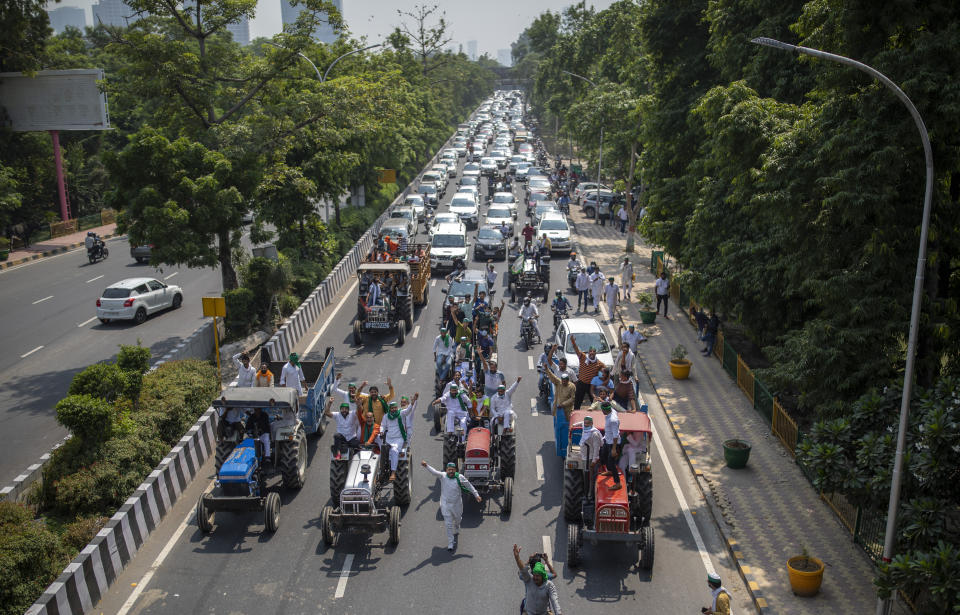 Indian farmers shout slogans as they ride tractors towards New Delhi in Noida, India, Friday, Sept. 25, 2020. Hundreds of Indian farmers took to the streets on Friday protesting new laws that the government says will boost growth in the farming sector through private investments, but they fear these are likely to be exploited by private players for buying their crops cheaply. (AP Photo/Altaf Qadri)