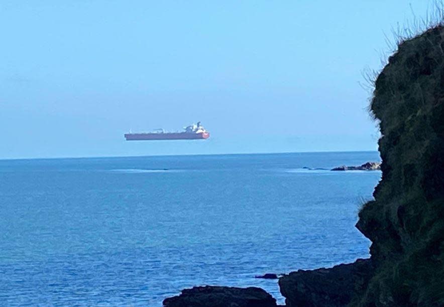 A ship appears to hover over the sea off the coast of Cornwall, England, in a photo captured by David Morris that shows the optical illusion known as 