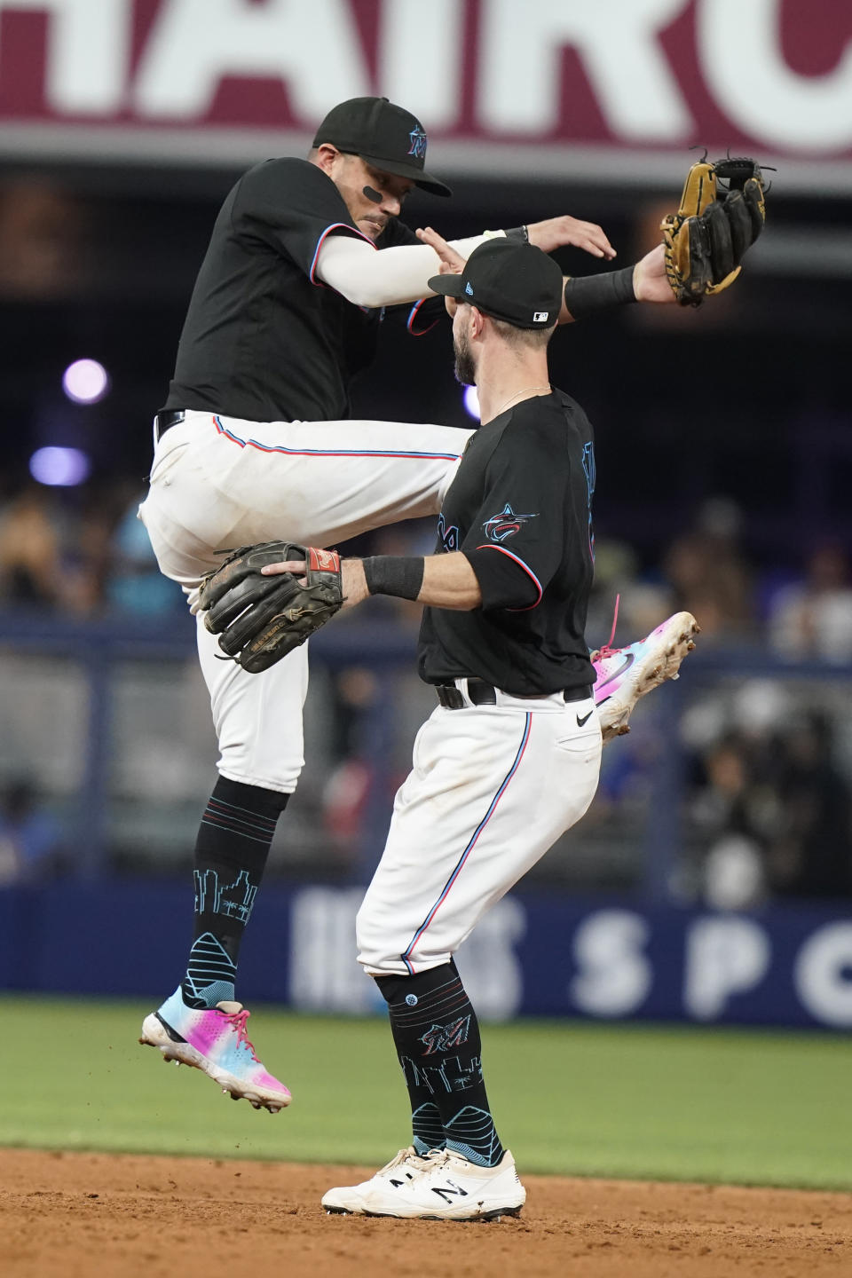 Miami Marlins shortstop Miguel Rojas (11) and third baseman Jon Berti (5) celebrate after defeating the New York Mets 6-2 in nine innings of a baseball game, Friday, Sept. 9, 2022, in Miami. (AP Photo/Marta Lavandier)