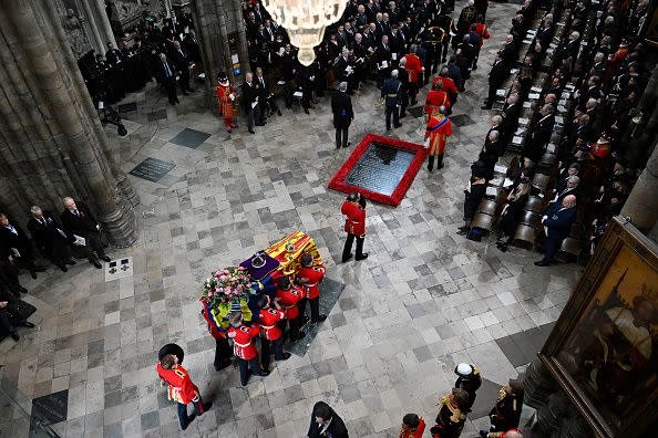 LONDON, ENGLAND - SEPTEMBER 19: The coffin of Queen Elizabeth II with the Imperial State Crown resting on top is carried by the Bearer Party into Westminster Abbey during the State Funeral of Queen Elizabeth II on September 19, 2022 in London, England. Elizabeth Alexandra Mary Windsor was born in Bruton Street, Mayfair, London on 21 April 1926. She married Prince Philip in 1947 and ascended the throne of the United Kingdom and Commonwealth on 6 February 1952 after the death of her Father, King George VI. Queen Elizabeth II died at Balmoral Castle in Scotland on September 8, 2022, and is succeeded by her eldest son, King Charles III.  (Photo by Gareth Cattermole/Getty Images)