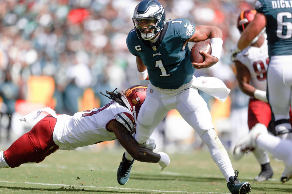 Philadelphia Eagles quarterback Jalen Hurts (1) carries the ball past Washington Commanders safety Kamren Curl (31) during the first half of an NFL football game, Sunday, Sept. 25, 2022 in Landover, Md. (Shaban Athuman/Richmond Times-Dispatch via AP)