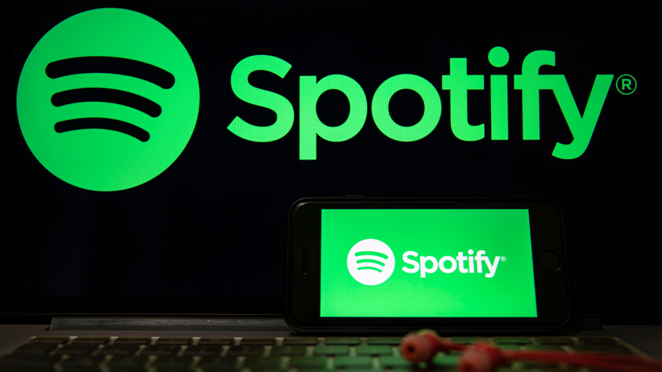 Spotify logo on laptop and on phone.