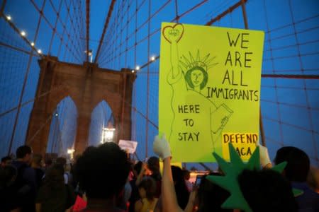 People march across the Brooklyn Bridge to protest the planned dissolution of DACA in Manhattan, New York City, U.S. September 5, 2017. REUTERS/Stephen Yang