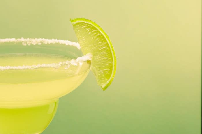 Close-up of a margarita glass with a lime wedge and salted rim