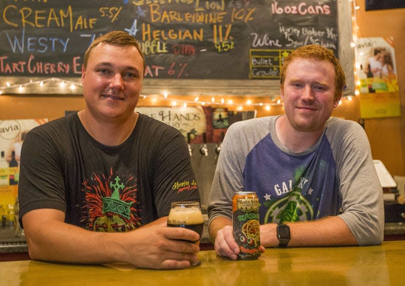 In this 2016 photo, Bare Hands Brewery owner Chris Gerard, left, stands with a coworker at the bar inside Bare Hands Brewery in Granger.