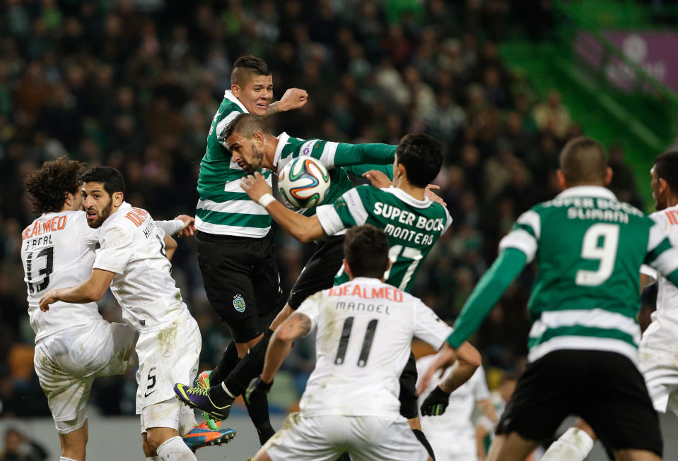 Sporting's Rojo, from Argentina, top, jumps for the ball during their Portuguese league soccer match with Academica, Sunday, Feb. 2 2014, at Sporting's Alvalade stadium in Lisbon. The game ended in a 0-0 draw. (AP Photo/Armando Franca)