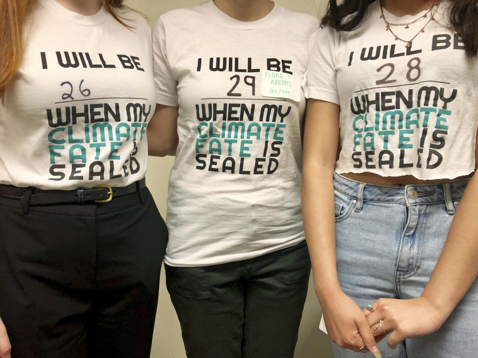 Student leaders with the lobbying group Renew Oregon, which helped craft landmark climate change legislation currently under debate in Oregon, pose to show their T-shirts after a news conference in Salem, Oregon, on June 20, 2019. Minority Republican senators walked out Thursday to block a vote on the proposal, which would be the second of its kind in the nation. That prompted Gov. Kate Brown, a Democrat, to activate the state police to bring absentee senators back against their will. (AP Photo/Gillian Flaccus)