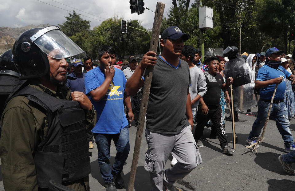 Partidarios del presidente boliviano Evo Morales marchan en apoyo a su reelección mientras la policía trata de mantenerlos separados de los manifestantes antigubernamentales en La Paz, Bolivia, el lunes 4 de noviembre de 2019. (AP Foto / Juan Karita)