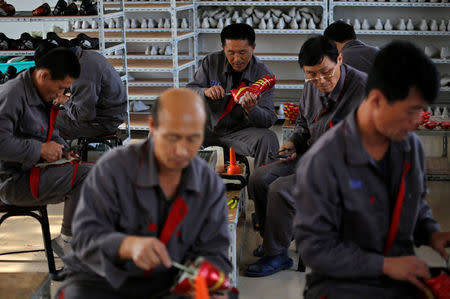 North Korean workers make soccer shoes inside a temporary factory at a rural village on the edge of Dandong October 24, 2012. REUTERS/Aly Song/File Photo