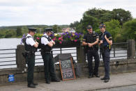 Officers of the Northern Ireland Police Service chat with colleagues from Ireland's Garda next to a sign left by tourists at the borderline between Northern Ireland and Ireland in St Belleek, in Fermanagh, Northern Ireland, July 19, 2018. REUTERS/Clodagh Kilcoyne