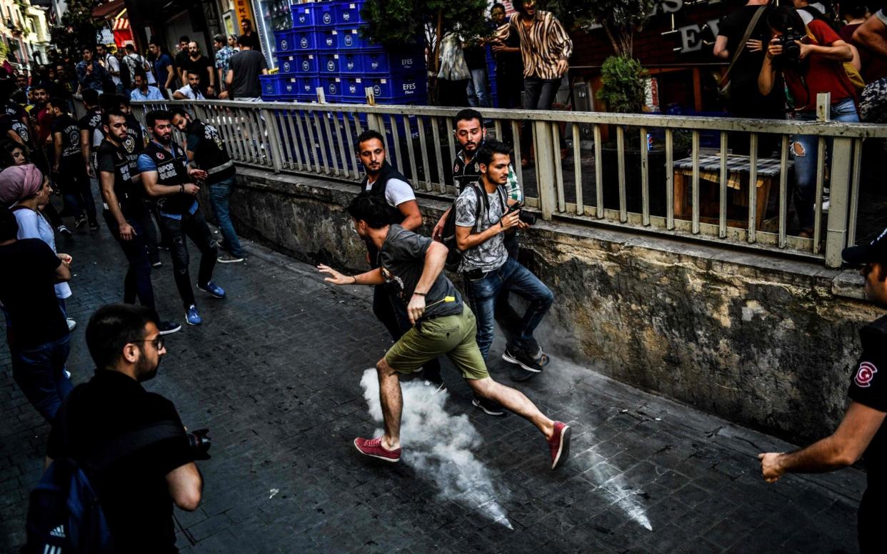 An LGBTI rights activist runs as people march on Sunday in Istanbul - AFP
