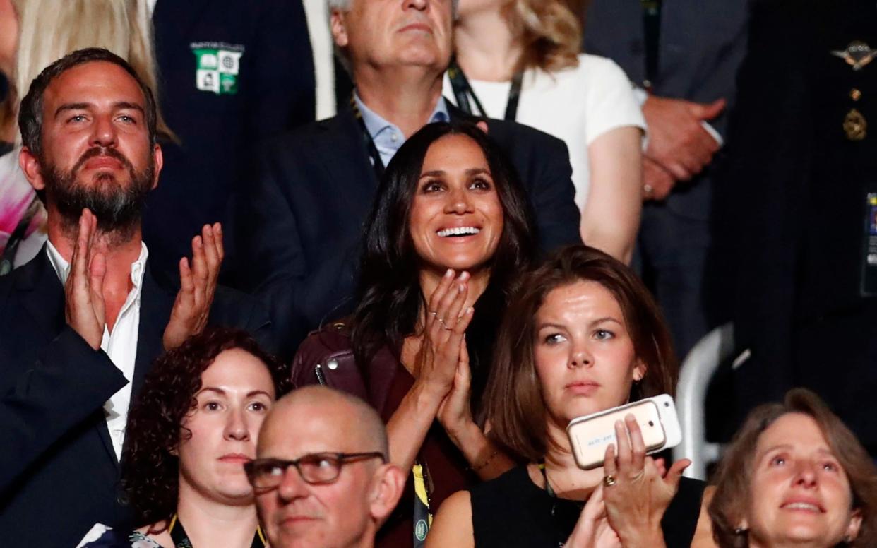 Meghan Markle (center, wearing dark red), girlfriend of Britain's Prince Harry, applauds during the opening ceremony for the Invictus Games in Toronto - REUTERS