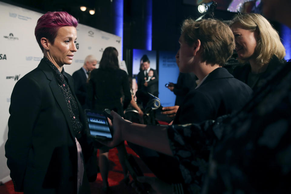 In this Wednesday, Oct. 16, 2019, photo, soccer star Megan Rapinoe talks to reporters on the red carpet of the Women's Sports Foundation's 40th annual Salute to Women in Sports in New York. Rapinoe, who was honored at the gala, won Sportswoman of the Year in the team category. She led the U.S. women's soccer team to victory at the World Cup in France and earned the FIFA Player of the Year award. (AP Photo/Mary Altaffer)