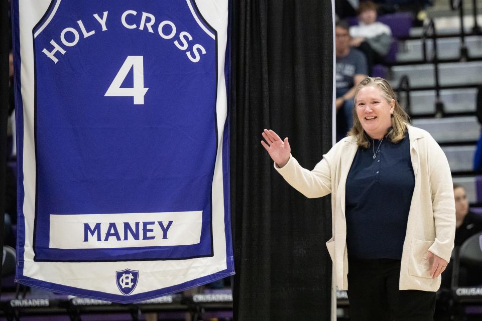 Lauren Maney George '96, stands with her jersey during Saturday's ceremony retiring the numbers of former Holy Cross female basketball players.