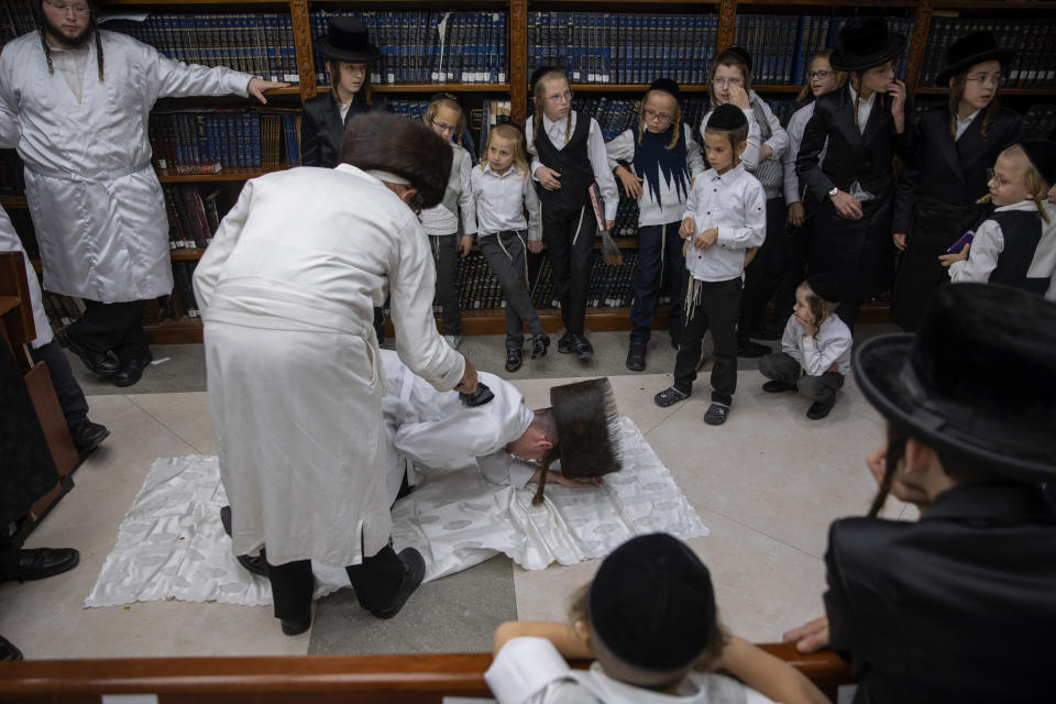 An ultra-Orthodox Jewish man whips a member of his Hasidic dynasty with a leather strap as a symbolic punishment for his sins last year's, during the traditional Malkot (whipping in Hebrew) ceremony, ahead of Yom Kippur that begins at sunset, in the city of Beit Shemesh, near Jerusalem, Wednesday, Sept. 15, 2021. Yom Kippur is Judaism's day of atonement, when devout Jews ask God to forgive them for their transgressions and refrain from eating and drinking, attending intense prayer services in synagogues. (AP Photo/Oded Balilty)