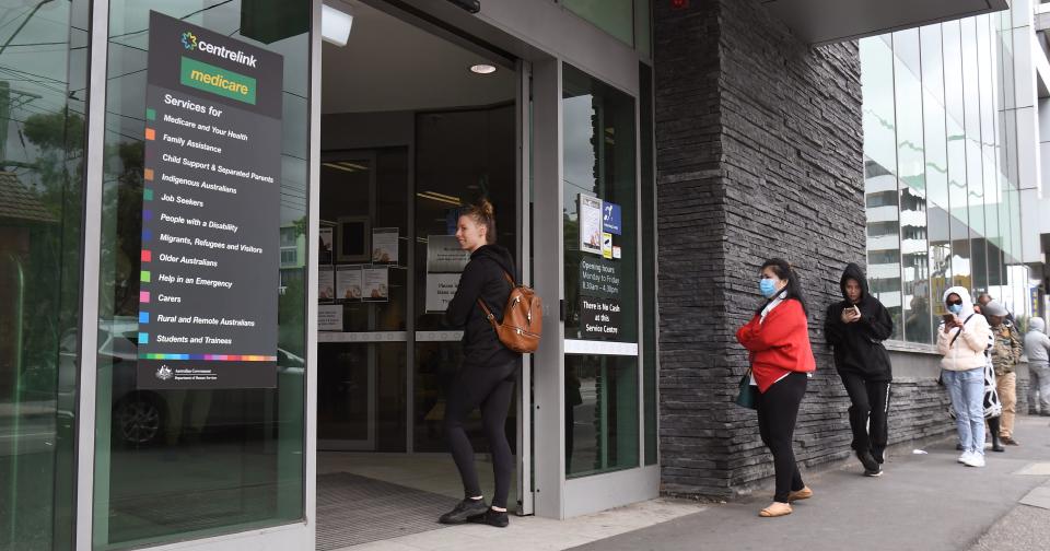 People queue outside an Australian government welfare centre, Centrelink, in Melbourne on March 23, 2020, as jobless Australians flooded unemployment offices around the country after Prime Minister Scott Morrison warned the coronavirus pandemic would cause an economic crisis akin to the Great Depression. - In scenes not seen in Australia for decades, queues stretched around the block at unemployment offices around the country as the forced closure of pubs, casinos, churches and gyms began at midday on March 23. (Photo by William WEST / AFP) (Photo by WILLIAM WEST/AFP via Getty Images)