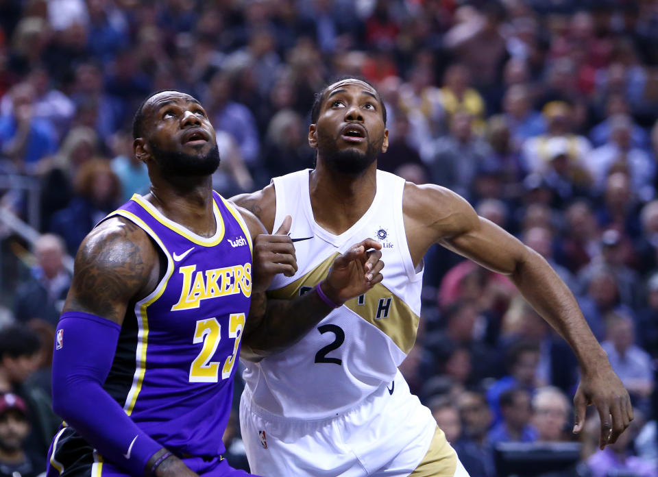 TORONTO, ON - MARCH 14:  LeBron James #23 of the Los Angeles Lakers battles for space with Kawhi Leonard #2 of the Toronto Raptors during the first half of an NBA game at Scotiabank Arena on March 14, 2019 in Toronto, Canada.  NOTE TO USER: User expressly acknowledges and agrees that, by downloading and or using this photograph, User is consenting to the terms and conditions of the Getty Images License Agreement.  (Photo by Vaughn Ridley/Getty Images)