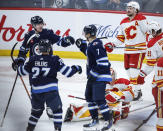 Winnipeg Jets' Tyler Toffoli (73), Nikolaj Ehlers (27) and Vladislav Namestnikov (7) celebrate Toffoli's goal against the Calgary Flames during the second period of an NHL hockey game Thursday, April 4, 2024, in Winnipeg, Manitoba. (John Woods/The Canadian Press via AP)