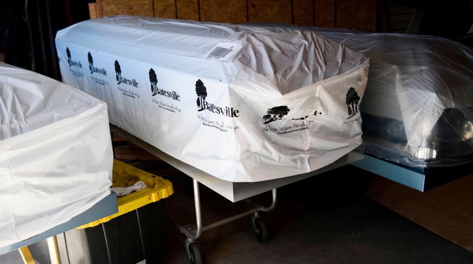 Covered empty caskets stand in a garage at Boyd Funeral Home on Jan. 14, 2021, in Los Angeles. (Photo: PATRICK T. FALLON via Getty Images)