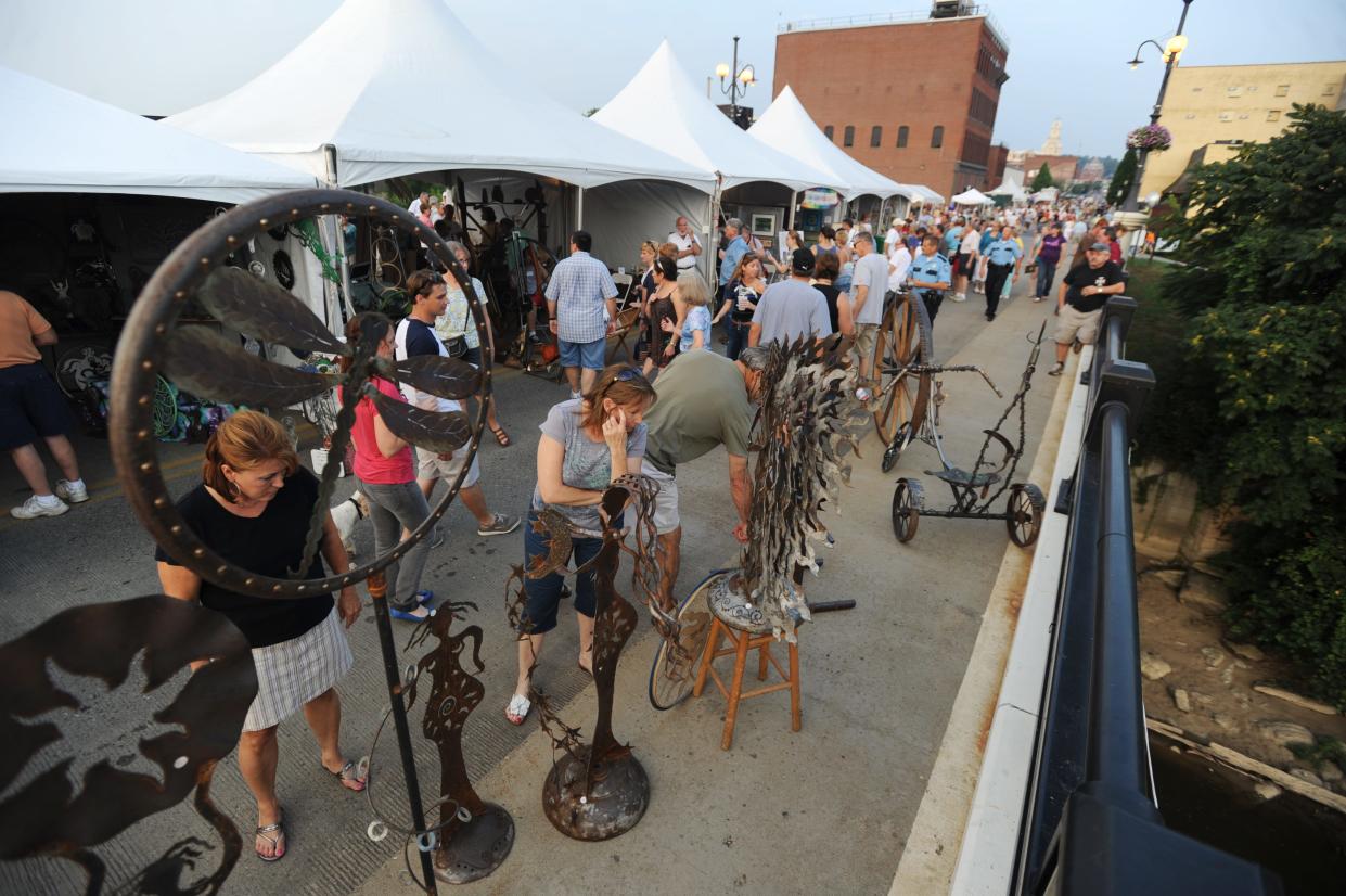 People attending the Y Bridge Arts Festival admire sculptures by an Indiana artist during a previous festival. The Muskingum County Community Foundation recently awarded ArtCOZ $5,000 to support the 2024 event.