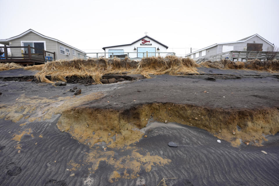 Houses rest behind beach erosion on Roy Carpenter's Beach, Thursday, Jan. 25, 2024, in South Kingstown, R.I. Experts say erosion and receding shorelines are becoming more common due to ocean rise and climate change. (AP Photo/Steven Senne)