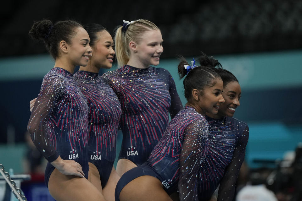 The United States team from left to right, Hezly Rivera, Suni Lee, Jade Carey, Jordan Chiles and Simone Biles pose for a picture during a gymnastics training session at Bercy Arena at the 2024 Summer Olympics, Thursday, July 25, 2024, in Paris, France. (AP Photo/Francisco Seco)