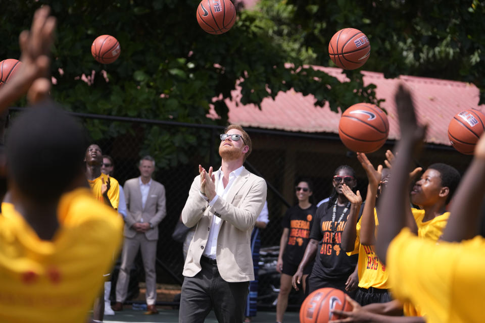 Prince Harry, center, plays basketball with children during the Giant of Africa Foundation at the Dream Big Basketball clinic in Lagos Nigeria, Sunday, May 12, 2024. Prince Harry and his wife Meghan are in Nigeria to champion the Invictus Games, which Prince Harry founded to aid the rehabilitation of wounded and sick servicemembers and veterans. (AP Photo/Sunday Alamba)