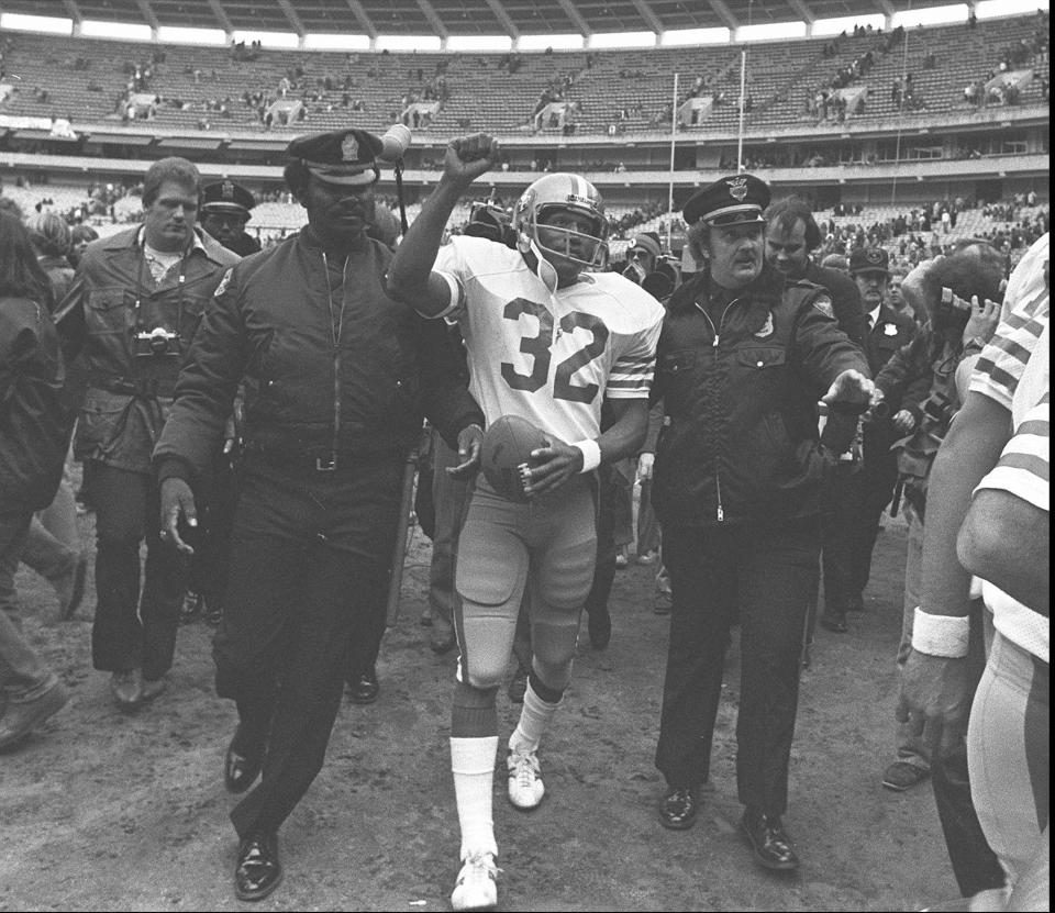 ARCHIVO - El corredor de los 49ers de San Francisco, O.J. Simpson es escoltado fuera del campo por la policía después del último partido de la NFL de su carrera, el 16 de diciembre de 1979, contra los Falcons de Atlanta en el Atlanta Fulton County Stadium en Atlanta, Georgia. O.J. Simpson, el laureado astro del fútbol americano y actor de Hollywood que fue absuelto de los cargos de doble asesinato de su exesposa y su amigo, pero luego declarado responsable en un juicio civil aparte, ha fallecido. Tenía 76 años. (Foto AP, archivo)