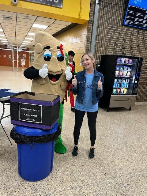 Airport counselor Jenny Przygodski is shown with the Taco Bell mascot, who gave out Cinnamon Twists to students who attended the expo.