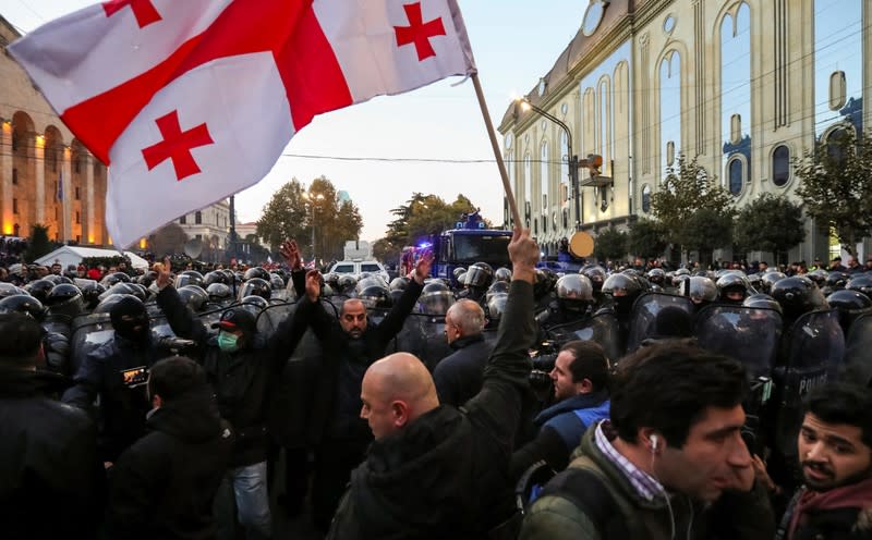 Riot police move to disperse demonstrators during a protest against the government demanding an early parliamentary election in Tbilisi