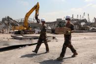 Members of the French military wear face masks and hold boxes during a joint effort to clear the rubble from port of Beirut