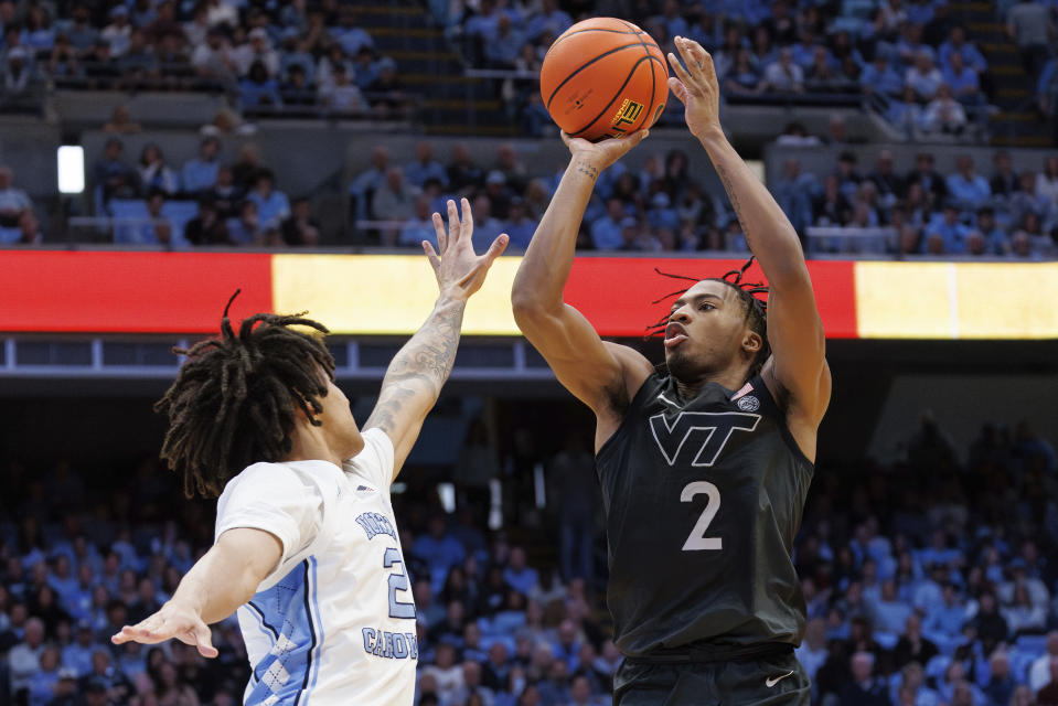 Virginia Tech's MJ Collins, right., attempts a shot over North Carolina's Elliot Cadeau, left, during the second half of an NCAA college basketball game in Chapel Hill, N.C., Saturday, Feb. 17, 2024. (AP Photo/Ben McKeown)