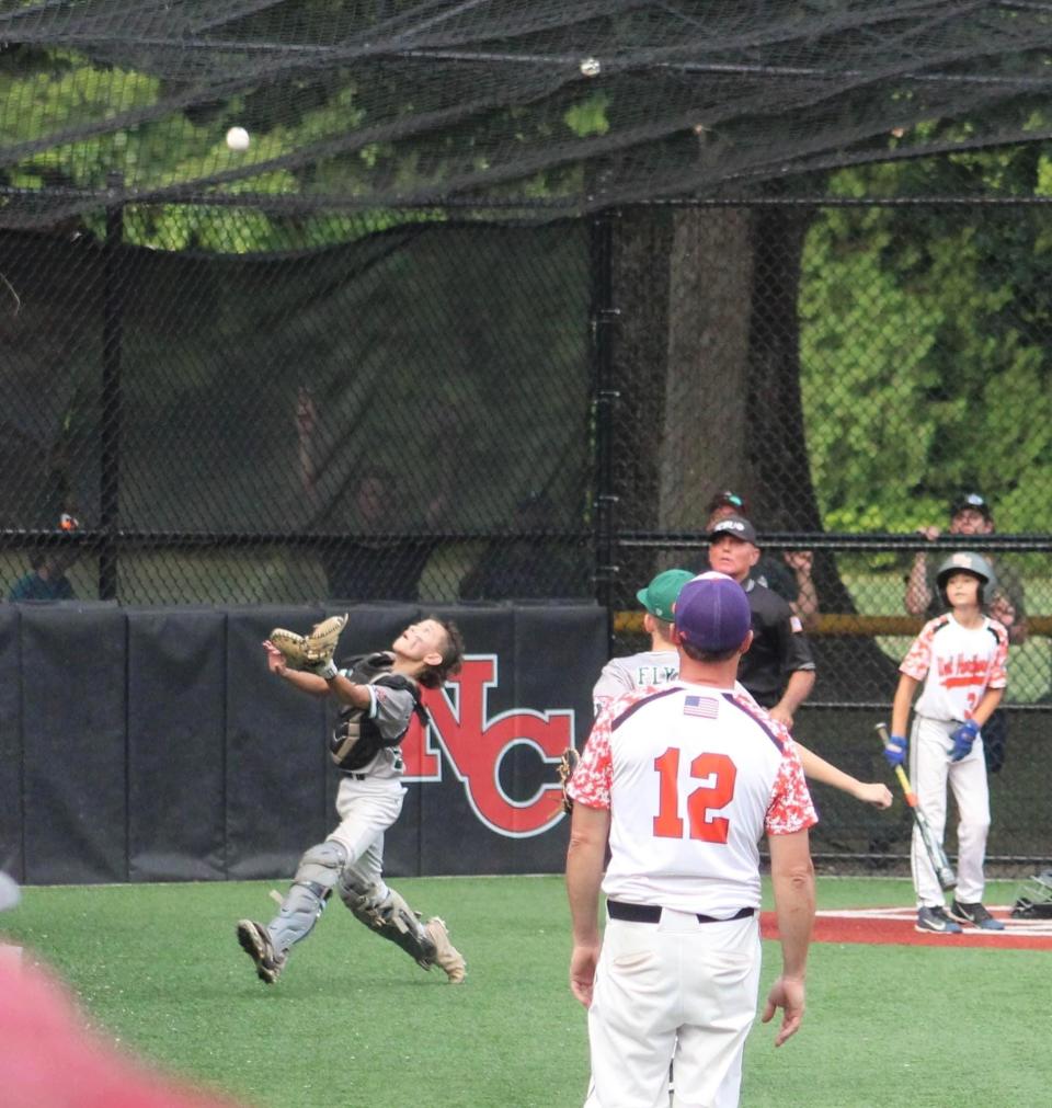 Dover 11U catcher Trey Longuil makes a catch in foul territory for the final out as Dover clinches its second consecutive New England championship , defeating West Hartford, Connecticut, 5-2, Friday, July 22, 2022 in New Canaan, Connecticut.