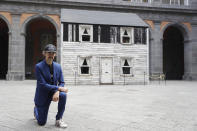 Artist Ryan Mendoza poses for photographers in front of the house of U.S. civil rights campaigner Rosa Parks, which he rebuilt for public display, in Naples, Italy, Tuesday, Sept. 15, 2020. The rundown, paint-chipped Detroit house where Parks took refuge after her famous bus boycott is on display in a setting that couldn't be more incongruous: the imposing central courtyard of the 18th century Royal Palace. (AP Photo/Gregorio Borgia)