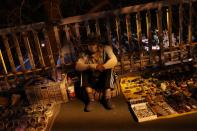 Street vendor waits for customers at his stall on a footbridge in Beijing