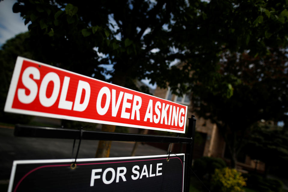 A real estate sign that reads "For Sale" and "Sold Above Asking" stands in front of housing in Vaughan, a suburb in Toronto, Canada, May 24, 2017.    REUTERS/Mark Blinch