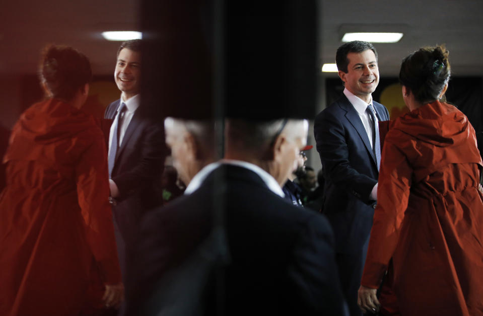 Reflected in the surface of a TV screen, democratic presidential candidate South Bend Mayor Pete Buttigieg meets with people after speaking at a culinary workers union hall Saturday, Jan. 11, 2020, in Las Vegas. (AP Photo/John Locher)